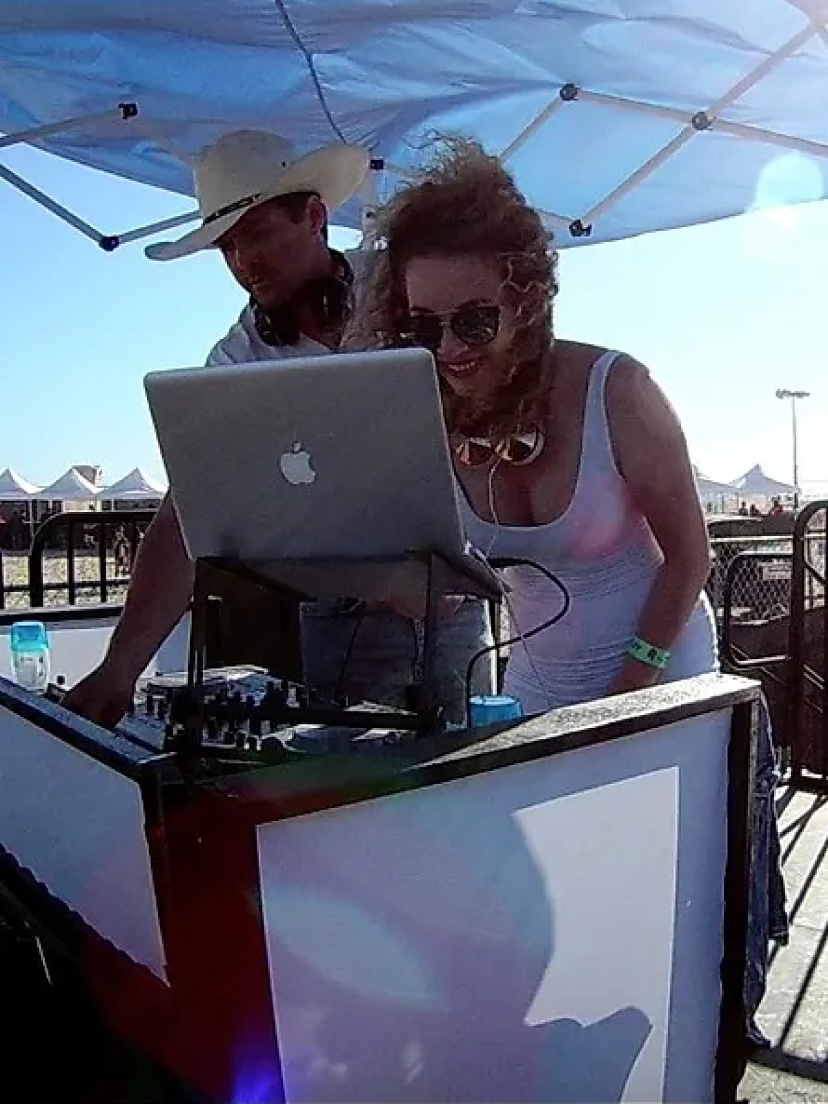 a man and a woman sitting at a table with a blue umbrella