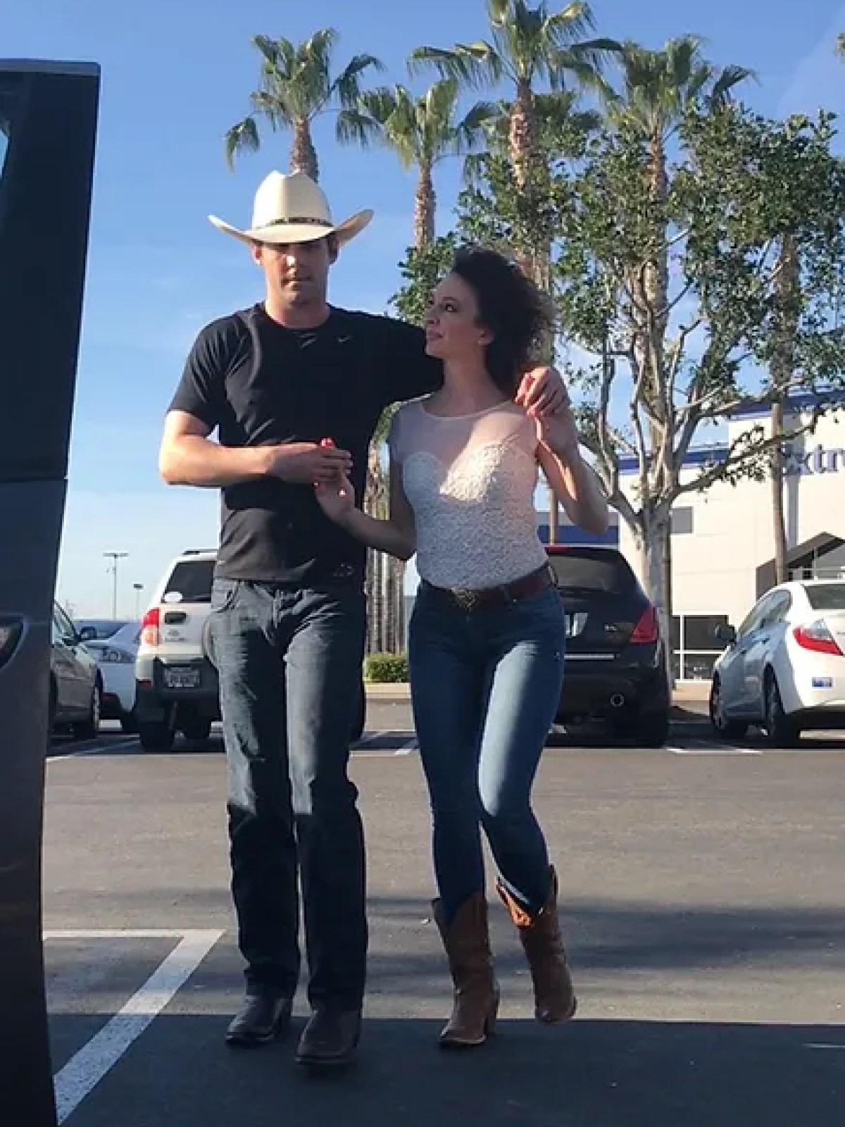 a man and a woman standing in a parking lot