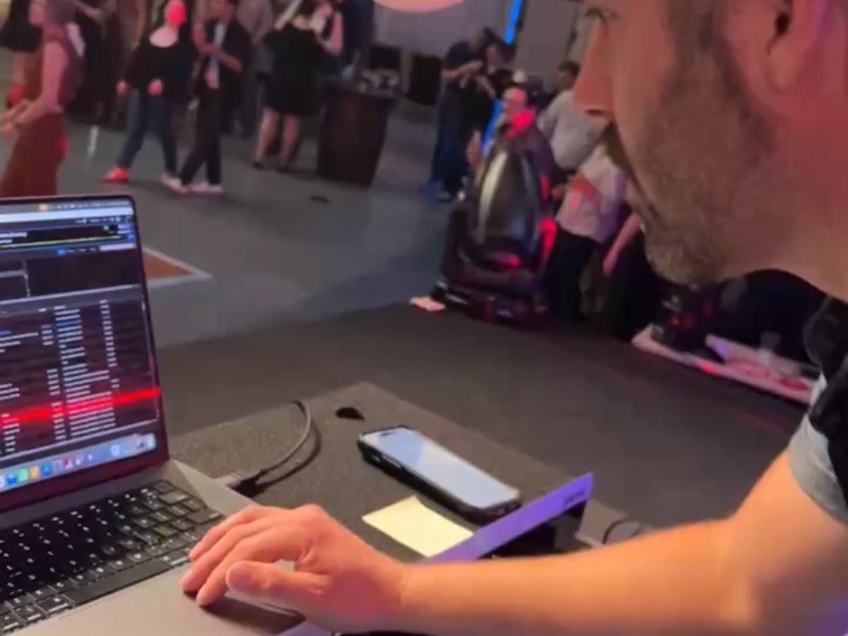 a group of people sitting at a table using a laptop computer