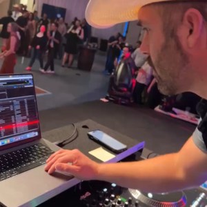 a group of people sitting at a table using a laptop computer