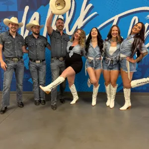 a group of people standing in front of a crowd posing for the camera