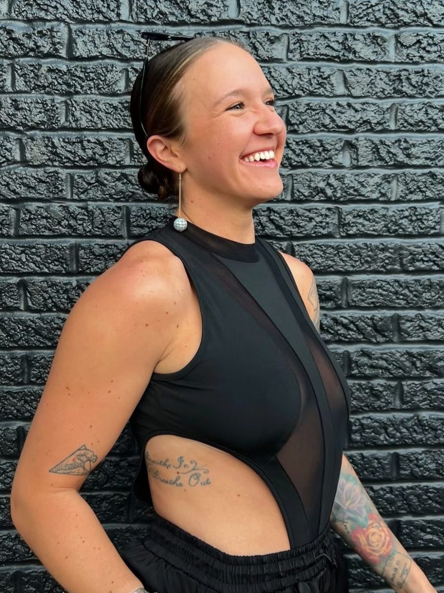 a woman sitting in front of a brick wall