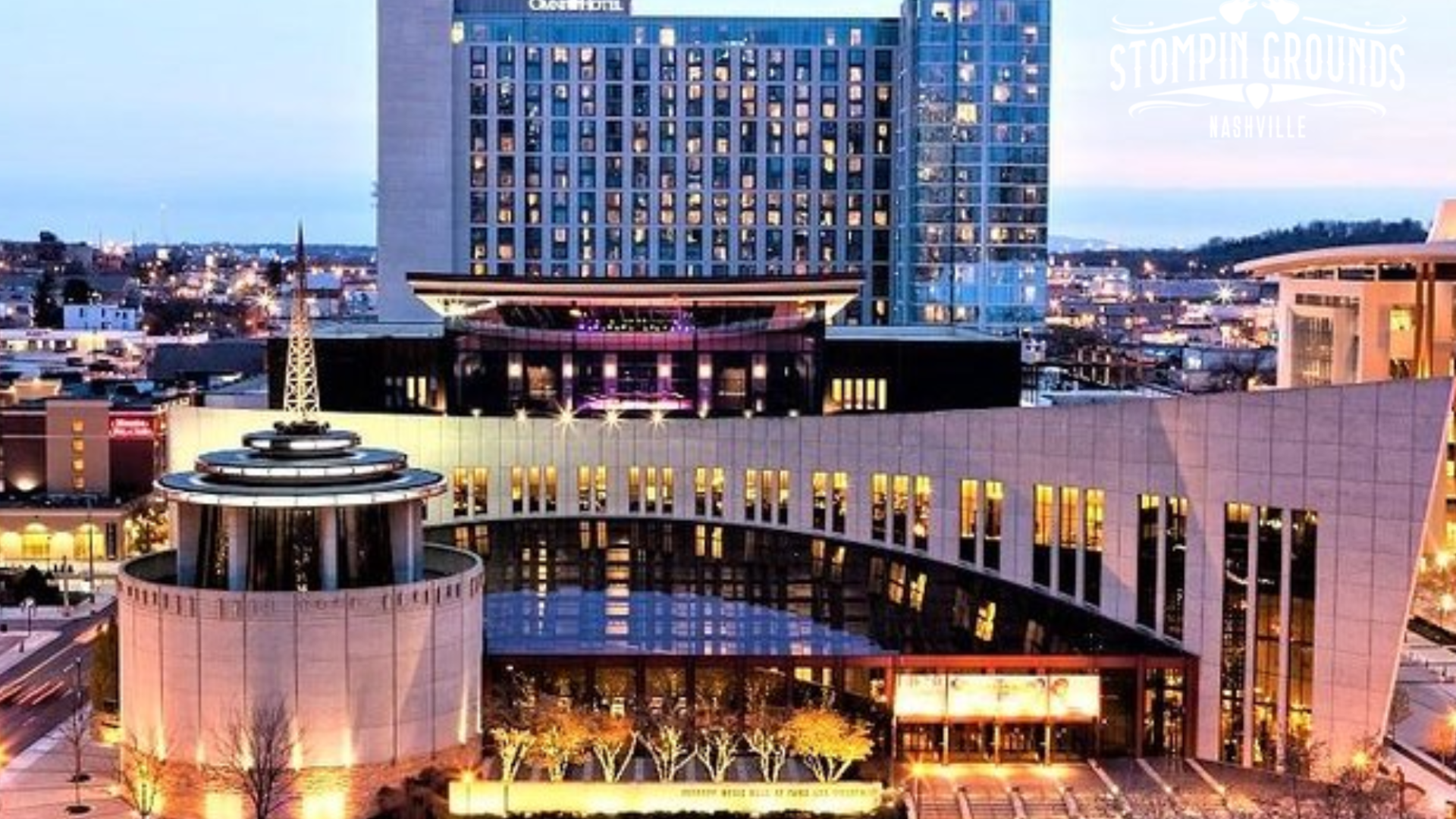 Country Music Hall of Fame building in a well-lit urban setting at twilight.